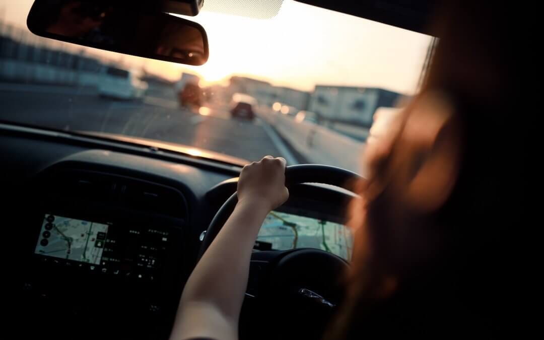 Woman driving car during sunrise